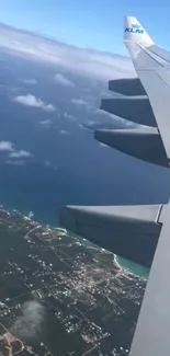 Airplane wing over ocean and landscape view.