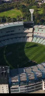 Aerial view of a green stadium surrounded by lush greenery.