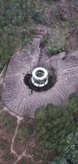 Aerial view of an ancient circular structure amid lush greenery.