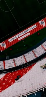 Aerial view of a stadium with green field and red track highlights.