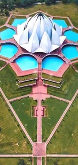 Aerial view of the Lotus Temple encircled by lush greenery and water.