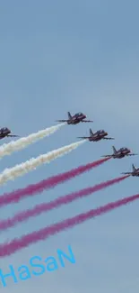 Aerobatic jets create smoke trails against a blue sky background.