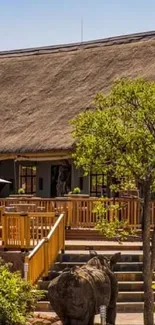 Rural African lodge with thatched roof and lush surrounding greenery.