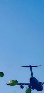 Dynamic wallpaper of airplane and parachutists in a clear blue sky.