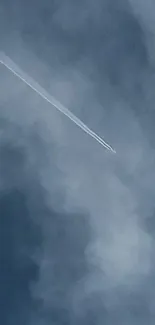 Airplane leaving a contrail across a cloudy blue sky.