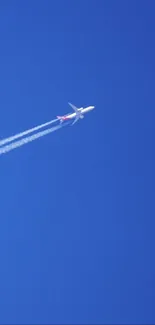 Airplane soaring in a clear blue sky with white contrails.