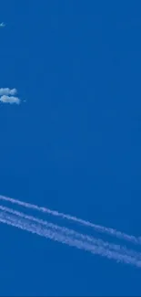 Airplane soaring through a clear blue sky, leaving a white contrail behind.