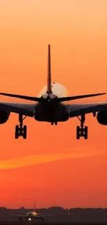 Silhouette of airplane against sunset sky with vibrant orange hues.