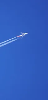 Airplane flying across a clear blue sky with contrails.