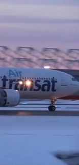 Air Transat airplane on runway during sunrise.