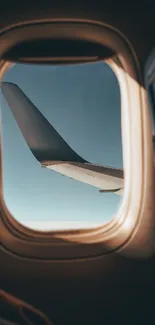 Airplane wing seen from a window under a clear sky.