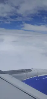 Airplane window view with blue sky and clouds.