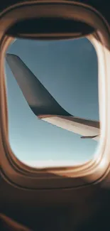 View of airplane wing through window with blue sky background.