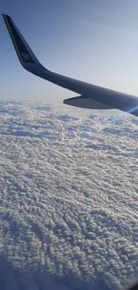 View from airplane window showing wing over fluffy white clouds.