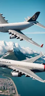 Two airplanes flying over mountains and ocean coastline.