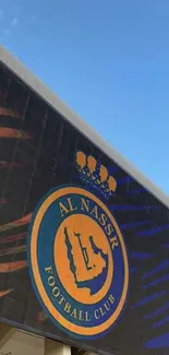 Al Nassr FC stadium with club emblem and vibrant blue sky.