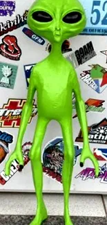 Bright green alien with colorful sticker background.