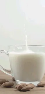Glass of almond milk with whole almonds on a wooden surface.
