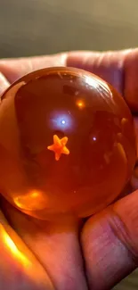 Amber sphere glowing in a hand, star inside.