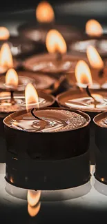 Close-up of glowing candles with warm flickering flames as phone wallpaper.