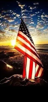 American flag against sunset on beach with ocean waves.