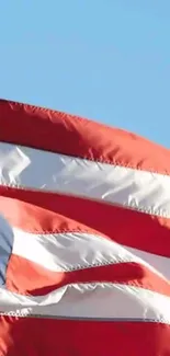 American flag waving on a bright blue sky background, showcasing vibrant colors.