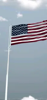 Waving American flag against a cloudy sky.