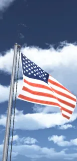 American flag waving against a blue sky with clouds.