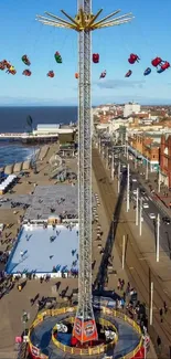 Aerial view of seaside amusement ride with vibrant blue sky.