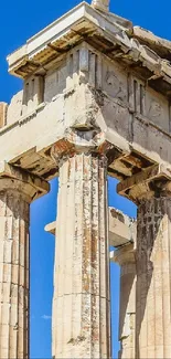 Ancient Greek columns under a blue sky, showcasing historic architecture.