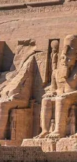 Ancient Egyptian statues carved into sandstone cliffs with desert background.