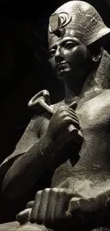 Ancient Egyptian statue in dark tones.