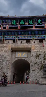 Ancient gate tower under a cloudy sky, showcasing traditional architecture.