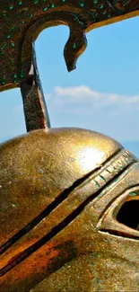 Ancient Greek helmet on a sandy beach with blue ocean and sky.