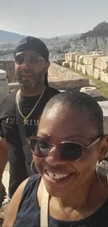 Couple exploring ancient ruins with scenic stone backdrop.