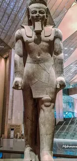 Egyptian statue in a modern museum interior, blending history with contemporary design.