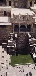 Intricate ancient stepwell with stone architecture and green pool center.