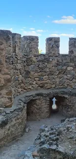 Ancient stone castle walls against blue sky background.