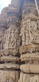 Intricate beige stone temple carvings in ancient architecture.