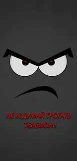 Minimalist angry face with red eyes on a charcoal gray mobile wallpaper.