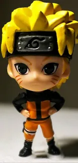 Chibi anime character figurine with yellow hair and orange outfit on a mobile wallpaper.