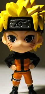 Anime figurine with yellow hair and orange outfit in focus.