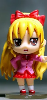 Anime figurine with yellow hair and red bow, striking a cute pose.