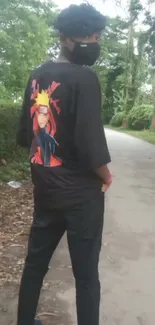 Anime character on black shirt in nature setting.