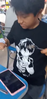 Person wearing anime-themed shirt dining casually.