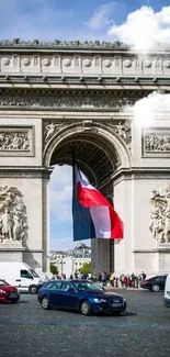 Arc de Triomphe with French flag under a clear blue sky.