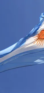 Argentinian flag waving in a bright blue sky.