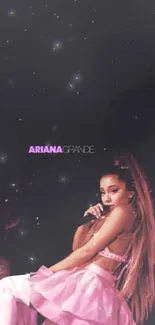 Ariana Grande in pink outfit against black starry background.