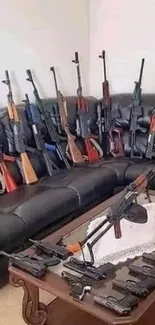 Wallpaper with multiple rifles and handguns displayed on a couch and table.