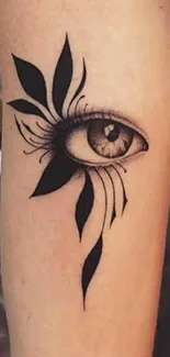 Intricate eye tattoo with artistic black ink design on arm.